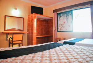 Postel nebo postele na pokoji v ubytování Hotel Hacienda Sánchez