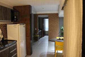 a kitchen with a refrigerator and a table in it at Lindo Apartamento - Beira Mar de Boa Viagem in Recife