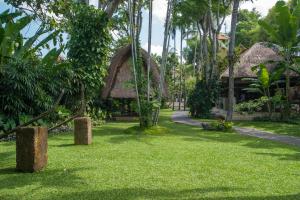 un complexe avec une cour avec des arbres et un bâtiment dans l'établissement Komaneka at Monkey Forest Ubud, à Ubud