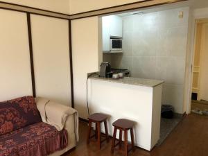 sala de estar con sofá y bar con taburetes en Apartamento no itaim bibi 264 localização perfeita en São Paulo