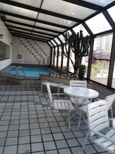 eine Terrasse mit einem Tisch, Stühlen und einem Pool in der Unterkunft Apartamento no itaim bibi 264 localização perfeita in São Paulo