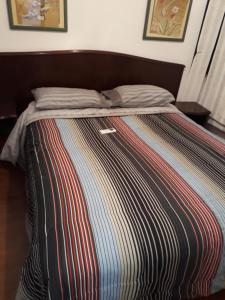 ein Bett mit einer bunten gestreiften Decke drauf in der Unterkunft Apartamento no itaim bibi 264 localização perfeita in São Paulo