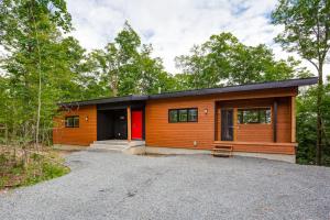 ein kleines Holzhaus mit einer roten Tür in der Unterkunft Le Panorama - Locations du Sommet in Morin Heights