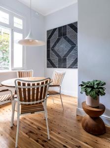 a dining room with a table and chairs and a potted plant at Bondi Beach House in Sydney