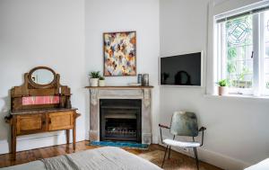 a bedroom with a fireplace and a chair and a mirror at Bondi Beach House in Sydney