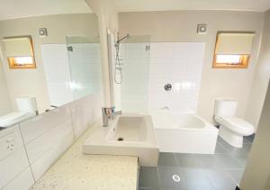 a white bathroom with a sink and a toilet at Bunny Box in Dinner Plain +6 photos