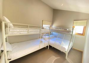 a room with three bunk beds in a room at Bunny Box in Dinner Plain