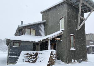 a house covered in snow in the yard at Bunny Box in Dinner Plain