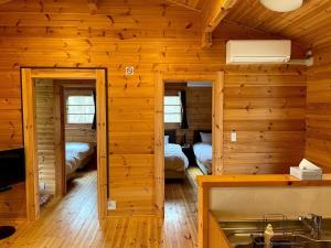 Cabaña de madera con cocina con 2 camas y lavamanos en Haramura CAFE Lodge - Vacation STAY 33104v, en Hara