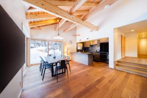 a kitchen and dining room with a table and chairs at Asagiri Chalet Hakuba in Hakuba