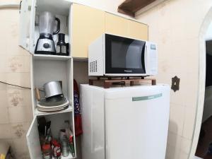 een televisie bovenop een koelkast in een keuken bij Sala-living/ 1 quadra da praia in Santos