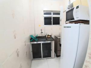 uma pequena cozinha com um lavatório e um frigorífico em Sala-living/ 1 quadra da praia em Santos