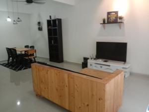 a living room with a flat screen tv and a table at Maryam Kiara 2 in Kertih