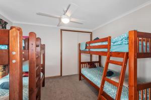 a room with four bunk beds and a ceiling fan at Sherry house in Bannockburn