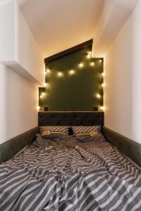 a bed in a room with lights on the wall at Дворівнева квартира Чорноморськ для 5 гостей - 65 in Chornomorsk
