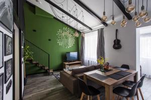 ein Wohnzimmer mit einem Tisch und einer grünen Wand in der Unterkunft Двухуровневая квартира Черноморск для 5 человек in Tschornomorsk