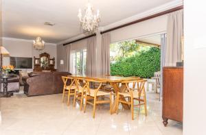 a dining room with a wooden table and chairs at Bela Rini Guesthouse in Bela-Bela