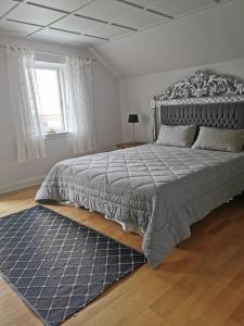 Un dormitorio con una cama grande y una alfombra azul en gl. Havn BnB, en Bogense