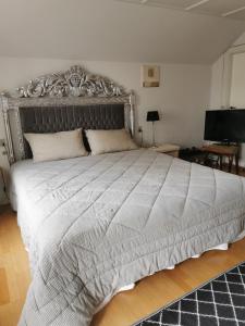 1 dormitorio con 1 cama grande y cabecero de plata en gl. Havn BnB, en Bogense