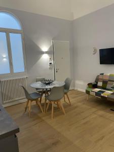 ein Wohnzimmer mit einem Tisch, Stühlen und einem Sofa in der Unterkunft Luna&Sole Oreste Apartments - Self check-in in Bari