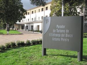 a sign in the grass in front of a building at Parador de Villafranca del Bierzo in Villafranca del Bierzo