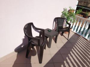 2 sillas y una mesa en el balcón en Casa Gia, en Bălnaca