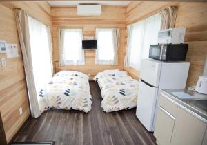 a small kitchen with two beds in a tiny house at Station Villa Plaisir Mt. Fuji in Fujikawaguchiko