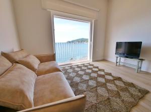 a living room with a couch and a large window at Casa Concha Apartamentos in Calella de Palafrugell