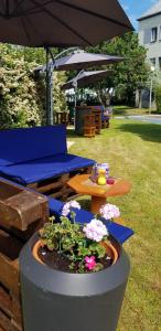 a patio with a table and an umbrella and flowers at Comfort Hotel Orléans Olivet in Olivet