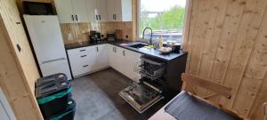 a small kitchen with a sink and a refrigerator at Ramlejowe Wzgórze - Sauna-Balia in Ostrzyce
