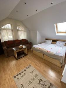 - une chambre avec un grand lit et un canapé dans l'établissement Flora Alpina, à Azuga