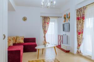 ein Wohnzimmer mit einem roten Sofa und einem Tisch in der Unterkunft Morsky in Năvodari