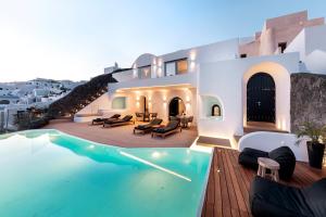 伊亚Olvos Luxury Suites的一栋房子前面有游泳池的别墅