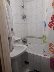 a white bathroom with a sink and a bath tub at apartment Galitskaya Square in Kyiv