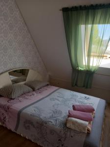 a small bedroom with a bed with a window at Jūras Vilks in Ventspils