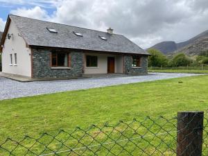 a stone house with a fence in front of it at Eagles Lodge in Killarney