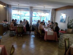 a group of people sitting at tables in a restaurant at Cafe Moselterrasse in Klotten