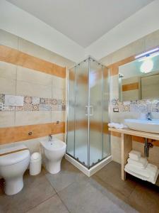 uma casa de banho com um chuveiro, um WC e um lavatório. em B&B MiMì em Porto Cesareo