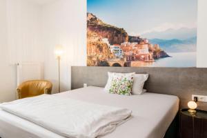 1 dormitorio con 1 cama grande y una pintura en la pared en Hotel Garni Villa Toskana en Parsberg