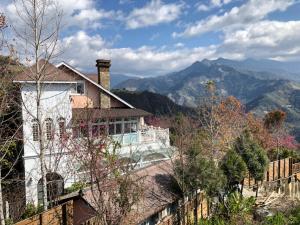 a house on a hill with mountains in the background at Aurora Villa in Renai