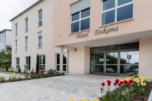 un edificio de hospital con flores delante en Hotel Garni Villa Toskana, en Parsberg