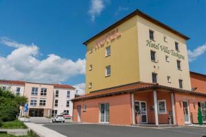 een geel en oranje gebouw op een straat met gebouwen bij Hotel Garni Villa Toskana in Parsberg