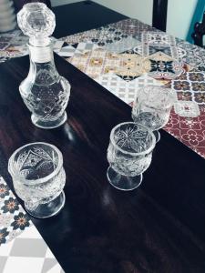 een groep glazen bekers op een tafel met een fles bij DIONI 2 in Chania