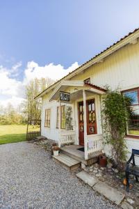 a small white house with a porch and a bench at Bäcks Bed & Breakfast in Vintrosa