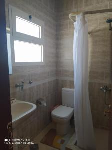 a bathroom with a toilet and a sink and a window at Studio 2 in Sharm El Sheikh