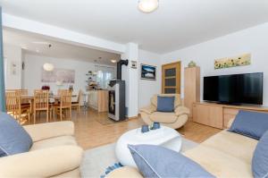 a living room with two couches and a tv at Dalmatian village charm - spacious villa with pool near Trogir in Primorski Dolac