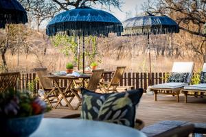 
a patio area with chairs, tables and umbrellas at Safari Moon Luxury Bush Lodge in Hoedspruit
