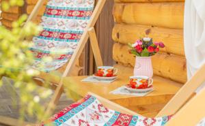 a table with two cups and a vase of flowers at SHODA in Ambrolauri