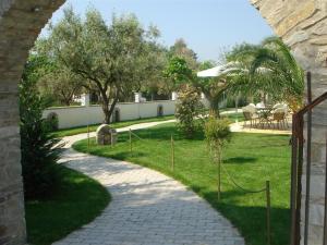 a walkway leading to a yard with trees and grass at To Portego tis Anatolis in Néa Péramos