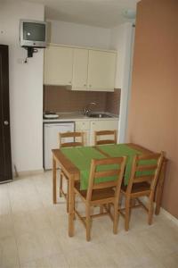 a kitchen with a table and chairs and a television at To Portego tis Anatolis in Nea Peramos